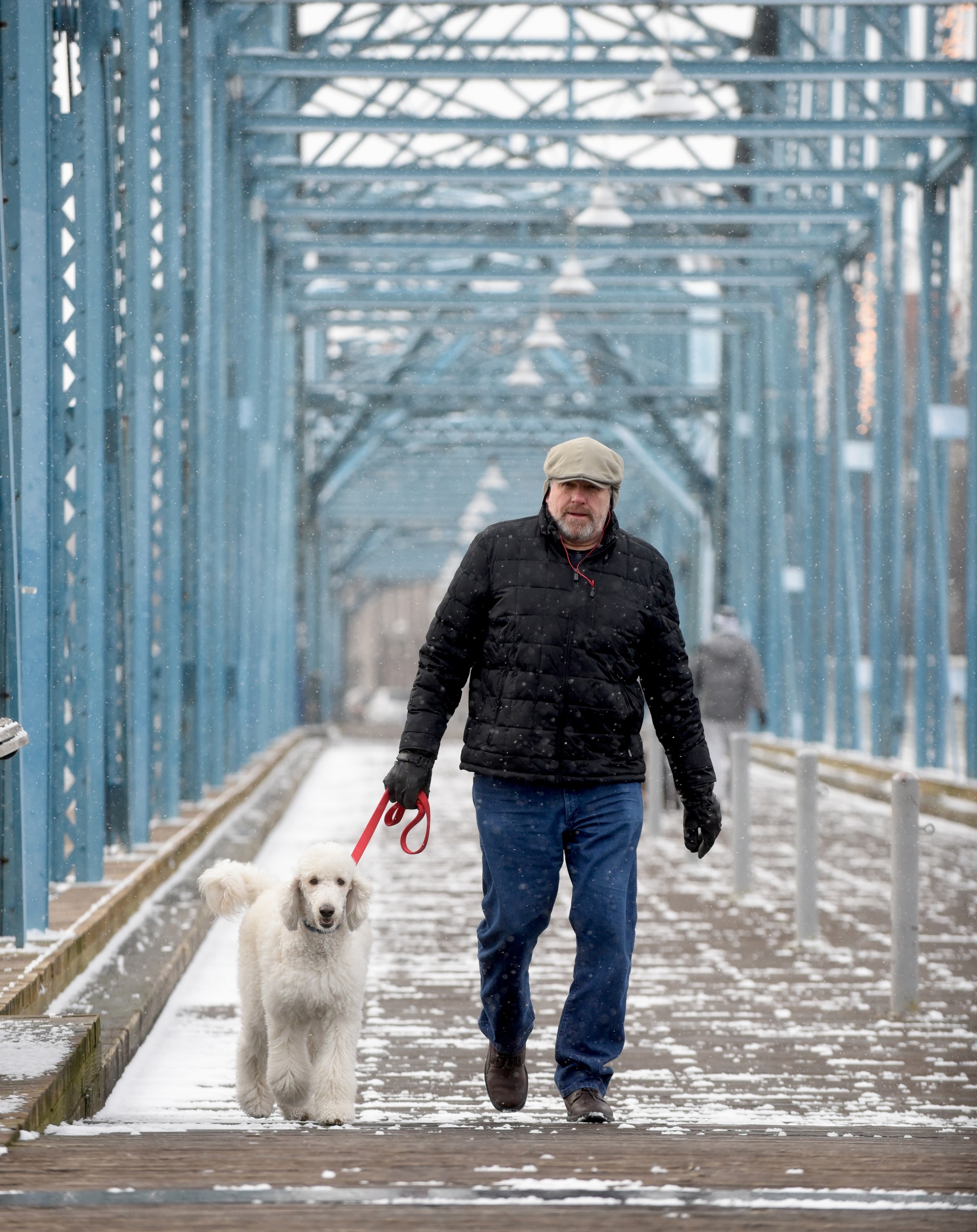 Jim Davis walks Scooter Tuesday, February 9, 2016, through light snow on the Walnut Street Bridge.