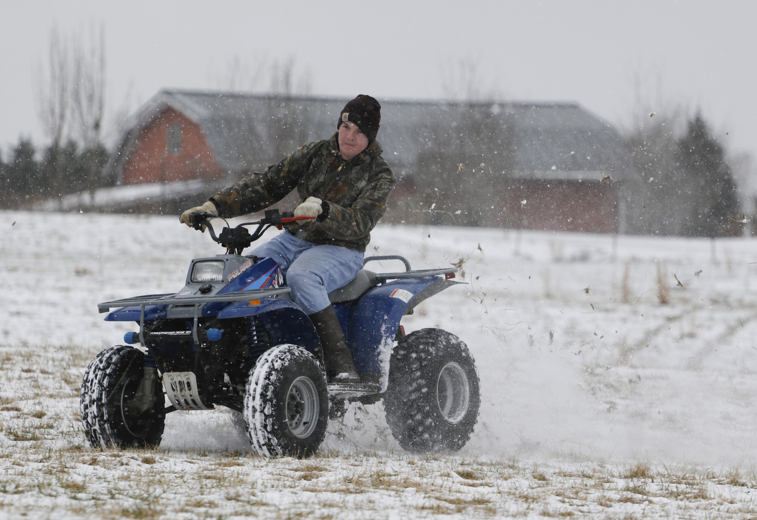 Staff Photo by Dan Henry / The Chattanooga Times Free Press- 2/9/16. Andrew Johnson, 17, uses a four wheeler to play in his family's snow dusted field atop Signal Mountain on Tuesday, February 9, 2015.