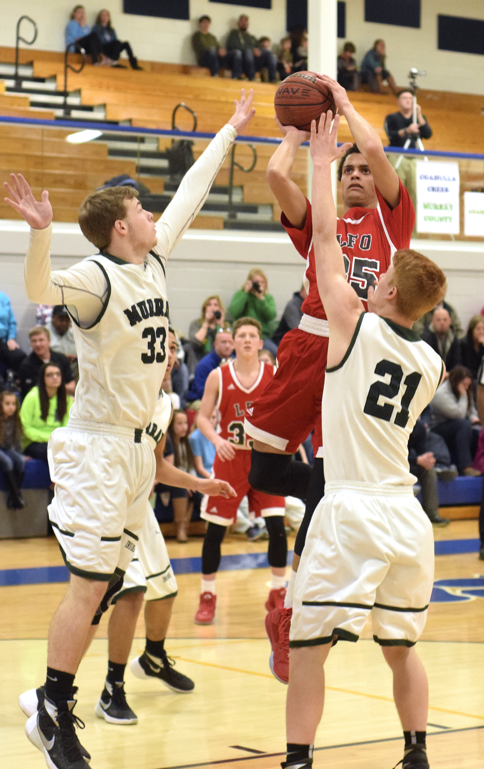 Lakeview's Zach Thompson (35) shoots over the defense of Murray County's Wyatt Stuckey (33) and Logan Bickford (21). The Lakeview-Fort Oglethrope Warriors faced the Murray County Indians in GHSA District 6-AAA basketball tournament at Ringgold High School, February 10, 2016.