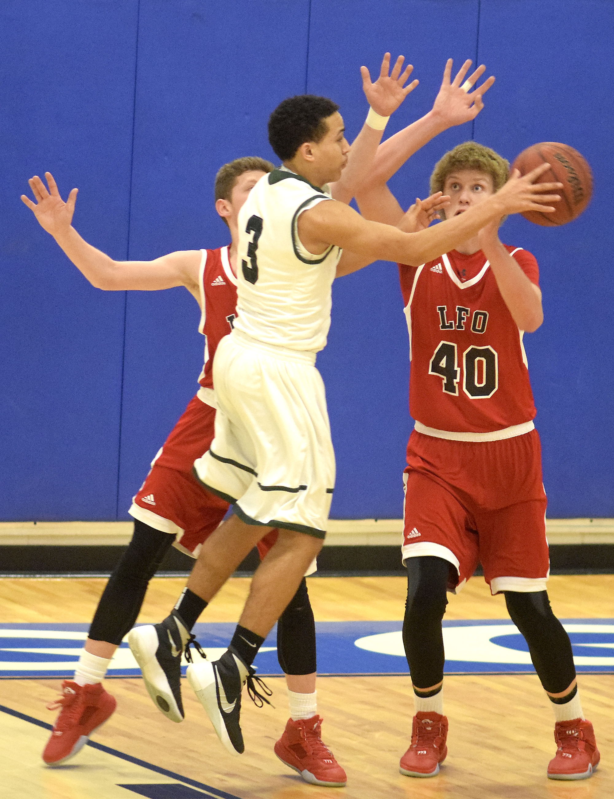 Murray County's Jordan Jackson (3) passes off in front of Lakeview's Triston Bennet (40) and another Warrior. The Lakeview-Fort Oglethrope Warriors faced the Murray County Indians in GHSA District 6-AAA basketball tournament at Ringgold High School, February 10, 2016.