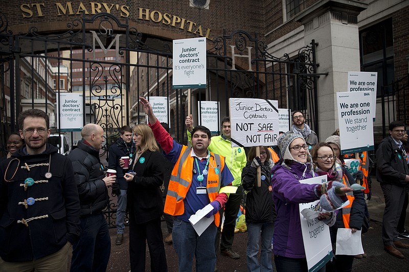 
              Junior doctors supported by other healthcare workers take part in a 24-hour strike as they stand on a picket line with placards outside St Mary's Hospital, which includes the private wing where the two royal babies were born in recent years, in London, Wednesday, Feb. 10, 2016. Thousands of junior doctors have walked off the job in England in a dispute over pay and working conditions. (AP Photo/Matt Dunham)
            