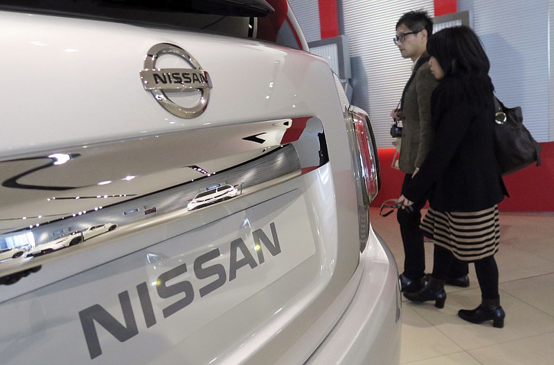 
              Visitors walk past a Nissan car at its global headquarters in Yokohama, near Tokyo, Wednesday, Feb. 10, 2016. Japanese automaker Nissan Motor Co. says its fiscal third quarter profit grew 25 percent to 127.2 billion yen ($1.1 billion) on strong sales. (AP Photo/Eugene Hoshiko)
            