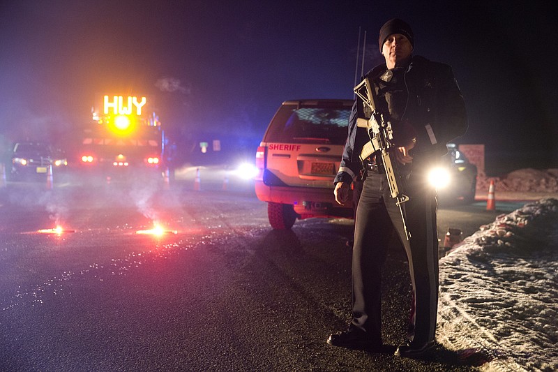 Sgt. Tom Hutchison stands in front of an Oregon State Police roadblock on Highway 395 between John Day and Burns by Oregon State police officers Tuesday, Jan. 26, 2016.