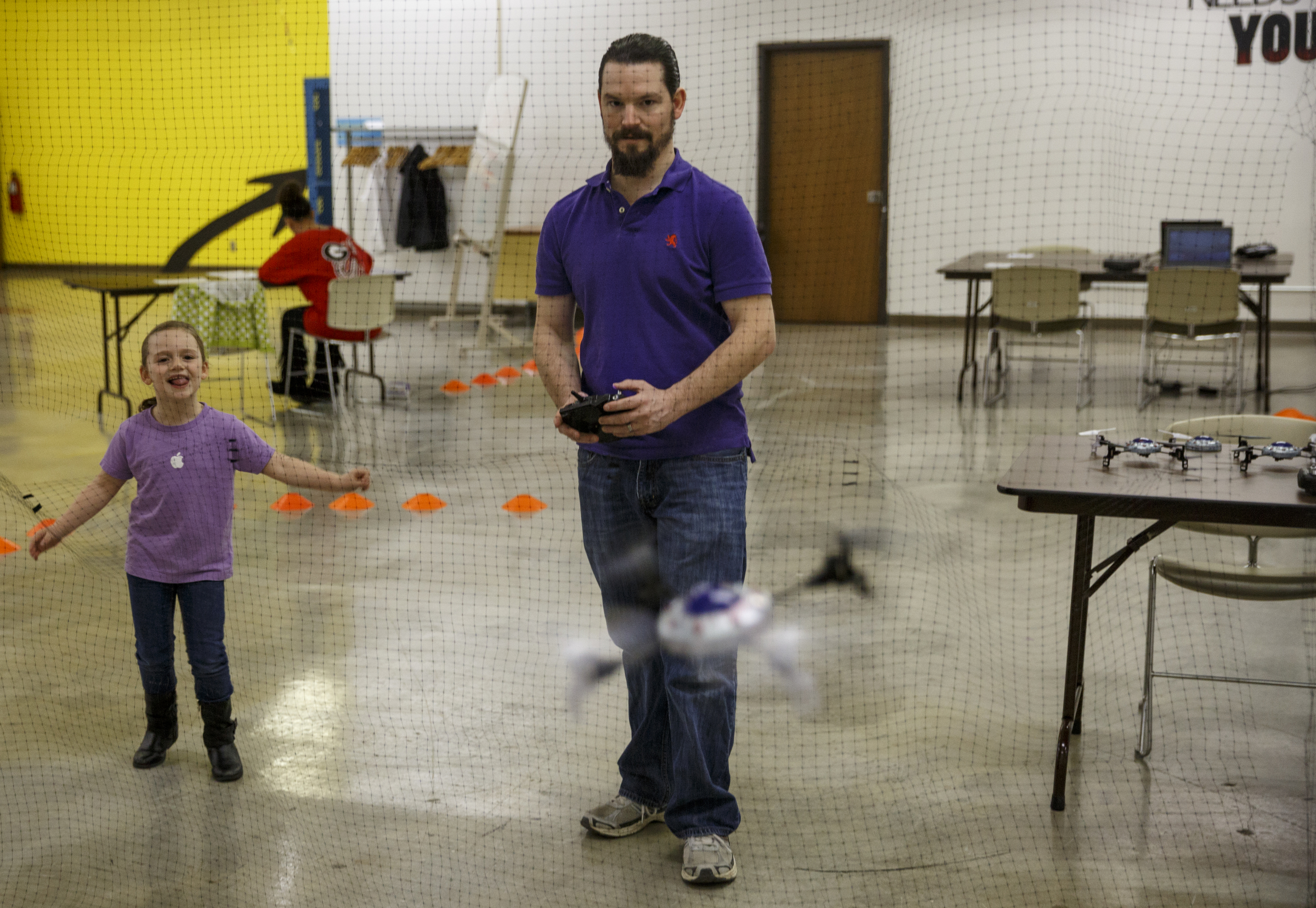 Sophia Candan, left, watches her father James pilot a radio controlled quad during the first session in an 8-week training course to teach people how to pilot drones at the Chattanooga Public Library on Saturday, Feb. 6, 2016, in Chattanooga, Tenn.