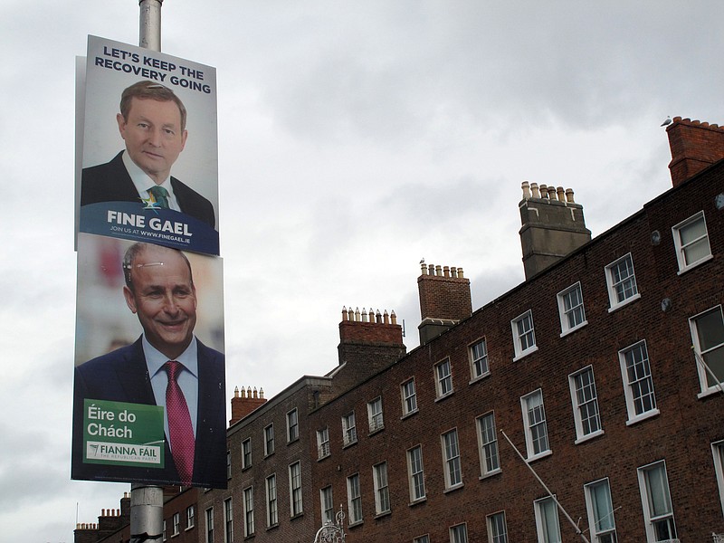 
              This photo taken Feb. 5, 2016, shows election posters of Prime Minister Enda Kenny, top, and Fianna Fail party leader Micheal Martin competing for space on a Merrion Square lamp post in Dublin, Ireland. Kenny hopes to keep his Fine Gael party in power following Ireland’s Feb. 26 election, but Martin’s opposition Fianna Fail, `Soldiers of Destiny’’ in Gaelic,  has formed most governments since the 1930's. The party’s election slogan 'Eire do chach’ means 'Ireland for all.’(AP Photo/Shawn Pogatchnik)
            