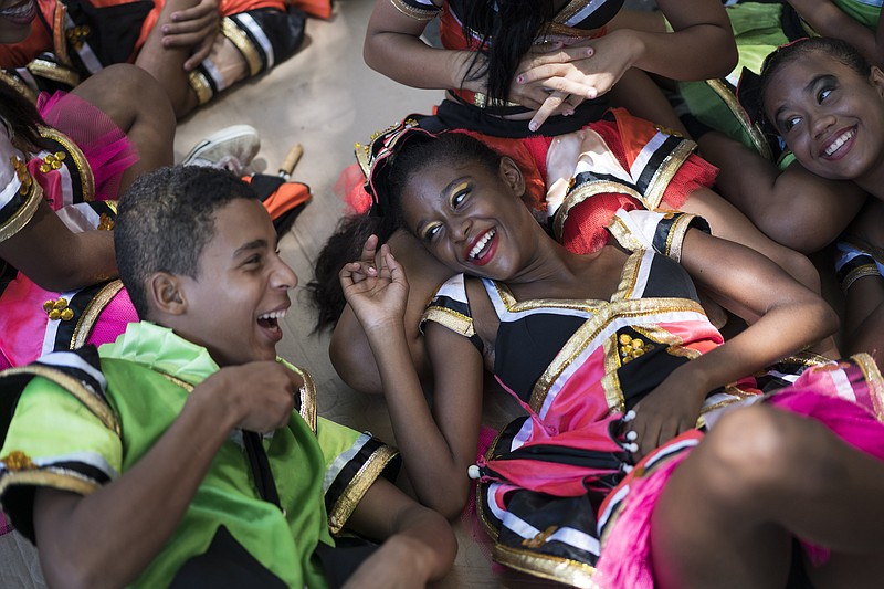 
              Young revelers joke with each other as they lay on the shade during the "Burial of the Mosquito" carnival block parade in Olinda, Pernambuco state, Brazil, Friday, Feb. 5, 2016. The parade that happens every year during carnival informs residents and tourists about the dangers of the Aedes aegypti and teaches them how to combat the mosquito. (AP Photo/Felipe Dana)
            