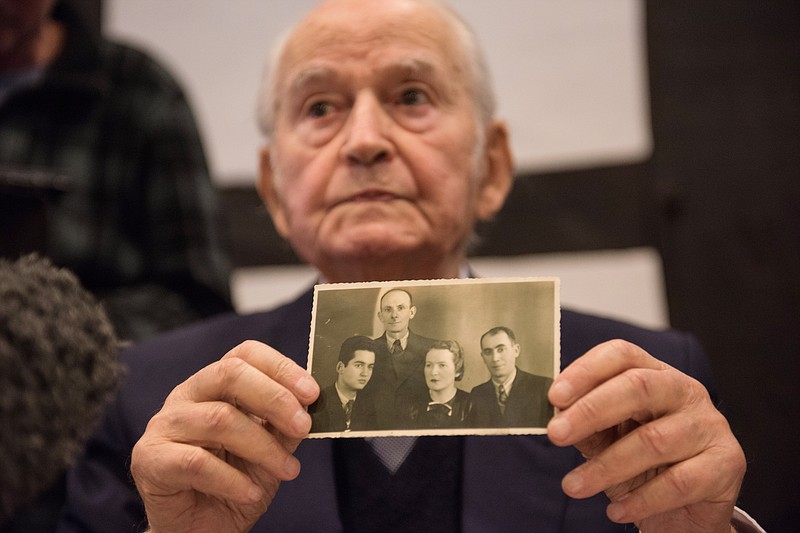 
              Auschwitz concentration camp survivor Leon Schwarzbaum presents an old photograph showing himself, left, next to his uncle and parents who all died in Auschwitz during a press conference in Detmold, Germany, Wednesday, Feb. 10, 2016. Reinhold Hanning, a 94-year-old former SS guard at the Auschwitz death camp is going on trial this week on 170,000 counts of accessory to murder, the first of up to four cases being brought to court this year in an 11th-hour push by German prosecutors to punish Nazi war crimes. (Bernd Thissen/dpa via AP)
            