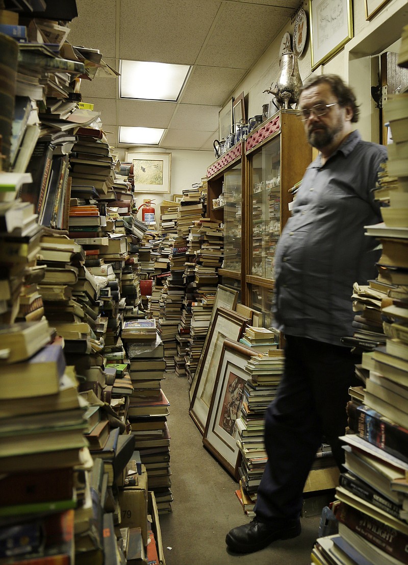 
              In this photo taken Monday, Feb. 8, 2016 Jonathan Klass, walks out of his office in his bookstore containing some 2 million books and prints in Johannesburg, South Africa. The Collectors Treasury, a three-storey bookshop owned by brothers Jonathan and Geoff Klass, is dedicated to preserving history and nostalgia and contains everything from VHS tapes of classic TV shows to floral porcelain trinkets, but books are prized above all. (AP Photo/Themba Hadebe)
            