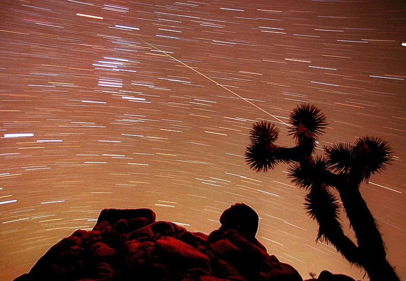 
              FILE - In this Nov. 17, 1998, file time exposure photo, a meteor streaks through the sky over Joshua trees and rocks at Joshua Tree National Monument in Southern California's Mojave Desert. President Barack Obama is granting national monument status to nearly 1.8 million acres of scenic California desert wilderness, including land that would connect what is now Joshua Tree National Park to other established national monuments and national parks in the area. Obama, in California this week for a fund-raising swing, plan to make the announcement Friday, Feb. 12, 2016. (AP Photo/Reed Saxon, File)
            