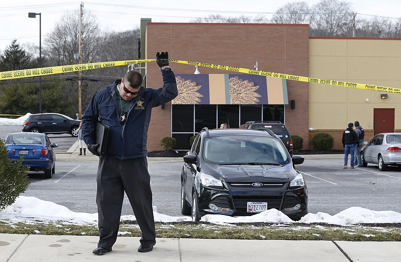 
              An investigator walks beneath a police tape line at the scene of a shooting at a shopping center in Abingdon, Md., Wednesday, Feb. 10, 2016. A man opened fire inside a shopping center restaurant during lunchtime. (AP Photo/Patrick Semansky)
            