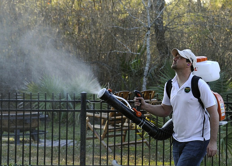 In this Wednesday, Feb. 10, 2016, photo, Darryl Nevins, owner of a Mosquito Joe franchise, sprays a backyard to control mosquitoes in Houston. Pest control companies in Texas are getting an early surge in business because of concerns that mosquitoes bearing the Zika virus will arrive from neighboring Mexico.