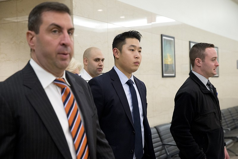 Police Officer Peter Liang, center, enters the courtroom after the lunch break in his trial on charges in the shooting death of Akai Gurley, Tuesday, Feb. 9, 2016, at Brooklyn Supreme court in New York. 