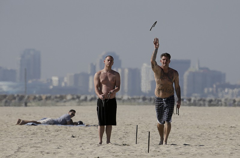 
              Two beach goers play horse shoes in the sand, Friday, Feb. 12, 2016, in Seal Beach, Calif. Ten days with record heat and no rain have Californians worrying about the drought again. (AP Photo/Chris Carlson)
            