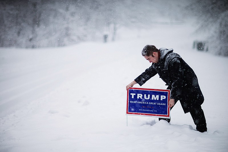 
              James Radcliffe, a volunteer for Republican presidential candidate Donald Trump, places a sign outside a home while walking through the snow knocking on doors in search of Trump supporters Friday, Feb. 5, 2016, in Londonderry, N.H.  (AP Photo/David Goldman)
            