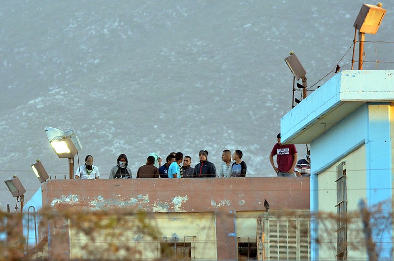 
              Inmates stand on the rooftop of the Topo Chico prison after a riot broke out around midnight, in Monterrey, Mexico, Thursday, Feb. 11, 2016. Dozens of inmates were killed and several injured in a brutal fight between two rival factions at the prison in northern Mexico, the state governor said. (AP Photo/Emilio Vazquez)
            