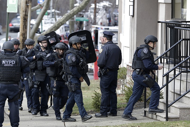 
              FILE - In a Wednesday, Feb. 10, 2016 file photo, New York City police enter a hotel, while searching for a man suspected of suspected of stabbing his girlfriend and all three of her small children with a kitchen knife in a brutal attack at a hotel in the Staten Island borough of New York. Police on Saturday, Feb. 13 arrested fugitive Michael Sykes, suspected of the stabbings, in Queens, ending a four-day manhunt. Sykes was brought back to a police precinct on Staten Island, where he was arrested on three counts of murder, attempted murder and robbery charges. (AP Photo/Seth Wenig, File)
            