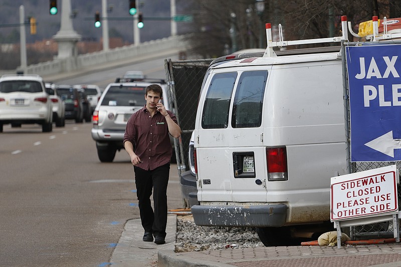 Staff Photo by Dan Henry / The Chattanooga Times Free Press- 2/12/16. Peter Hennigan navigates a closed section of sidewalk along Market Street on Friday, February 12, 2016 while making his way from his job at 212 Market Restaurant to his vehicle. 