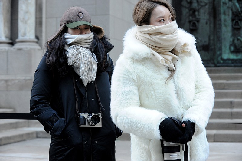 
              Street photographers brave the cold to photograph guests arriving to the Alexander Wang Fall 2016 show during Fashion Week, Saturday, Feb. 13, 2016, in New York. Bitter temperatures and biting winds had much of the northeastern United States bundling up for the some of the worst cold of the winter — a snap so bad it forced an ice festival in Central Park to cancel and caused an Interstate pileup that killed three. "These temperatures can be life threatening — especially for seniors, infants and people with medical conditions," New York City Mayor Bill de Blasio said. Stay indoors and take care of each other, he counseled. (AP Photo/Diane Bondareff)
            