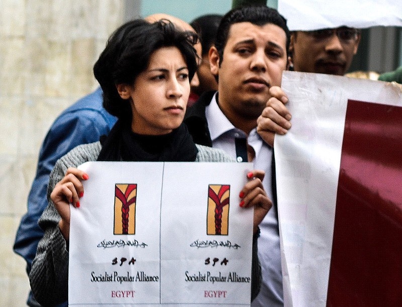 
              FILE - In this Jan. 24, 2015 photo, 32-year-old mother Shaimaa el-Sabbagh holds a poster during a protest in downtown Cairo. Egypt's highest appeals court on Sunday, Feb. 14, 2016 overturned the conviction of a police officer sentenced to 15 years in prison for the killing of a el-Sabbagh in a January 2015 shooting captured on video and photos. (AP Photo/Mohammed El-Raaei, File)
            