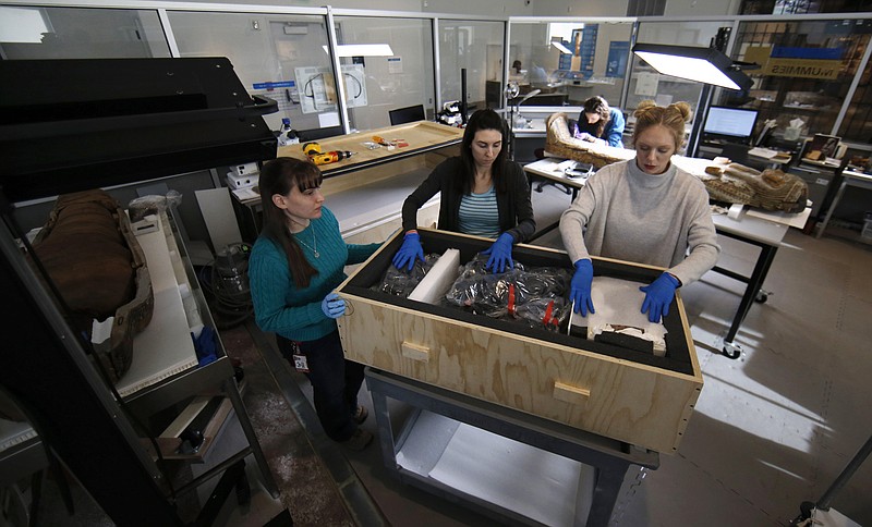 
              In this Thursday, Jan. 28, 2016, photo, collections technicians Ashley Scott, from left, Severine Craig and Taylor Barrett pack a crate of artifacts at the Penn Museum in Philadelphia. The archaeology museum has moved thousands of ancient treasures offsite and is using vibration sensors to monitor delicate items still on display while an earth-shaking demolition project continues next door. (AP Photo/Matt Slocum)
            