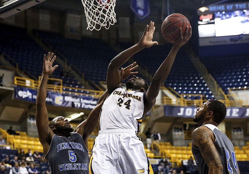 Chattanooga guard Casey Jones (24) shoots between Wesleyan forwards Trey Suttles (5) and Leland Robinson during the Mocs' home basketball game against Tennessee Wesleyan at McKenzie Arena on Tuesday, Dec. 8, 2015, in Chattanooga, Tenn.