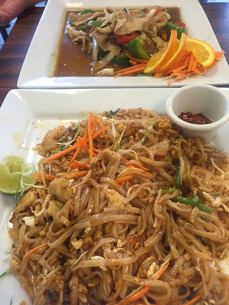 In the foreground is the Pad Thai with Thai rice noodles with eggs, bean sprouts and ground peanuts in a tamarind sauce. Above it is the Sweet Basil stir fry with chicken, bell pepper, basil, onion and minced chili sauce.