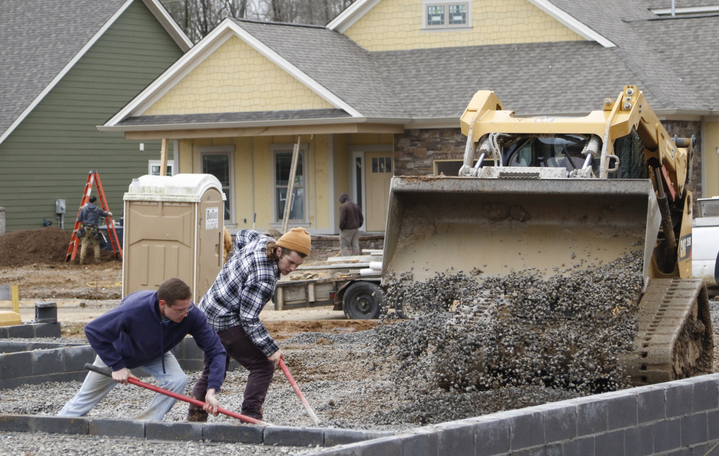 Staff Photo by Dan Henry / The Chattanooga Times Free Press- 2/16/16. Collin Heard, left, and Michael Higgins Jr. level gravel while doing site work in preparation to pour a driveway at a new subdivision being developed off of Pitts Road in Hixson on Tuesday, February 16, 2016. Recent precipitation has saturated the ground and caused some area construction projects to be delayed.