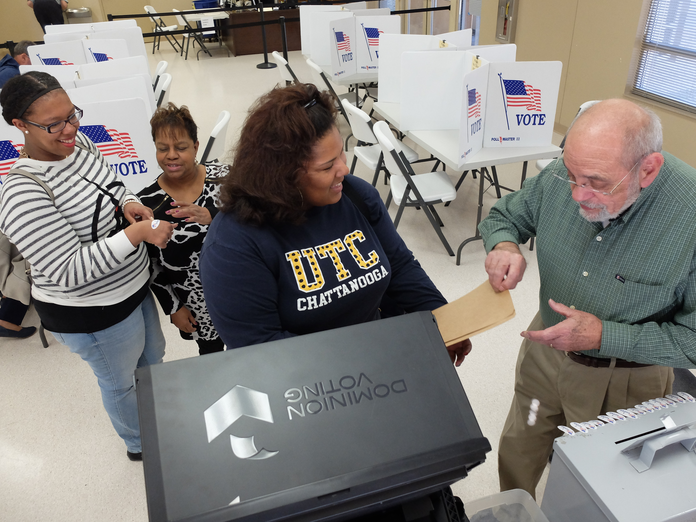 Early voter's Kendra Miller, left, and Kenisha Miller, center, receive help with their ballots from Volunteer Election Officer Linda Thompson, second from left, and Ballot Box Judge Byerly Morgan on Friday afternoon at the Hamilton County Election Commission offices near Amnicola Highway. As of 3:18 p.m., there were more than 320 ballots cast at the headquarters.