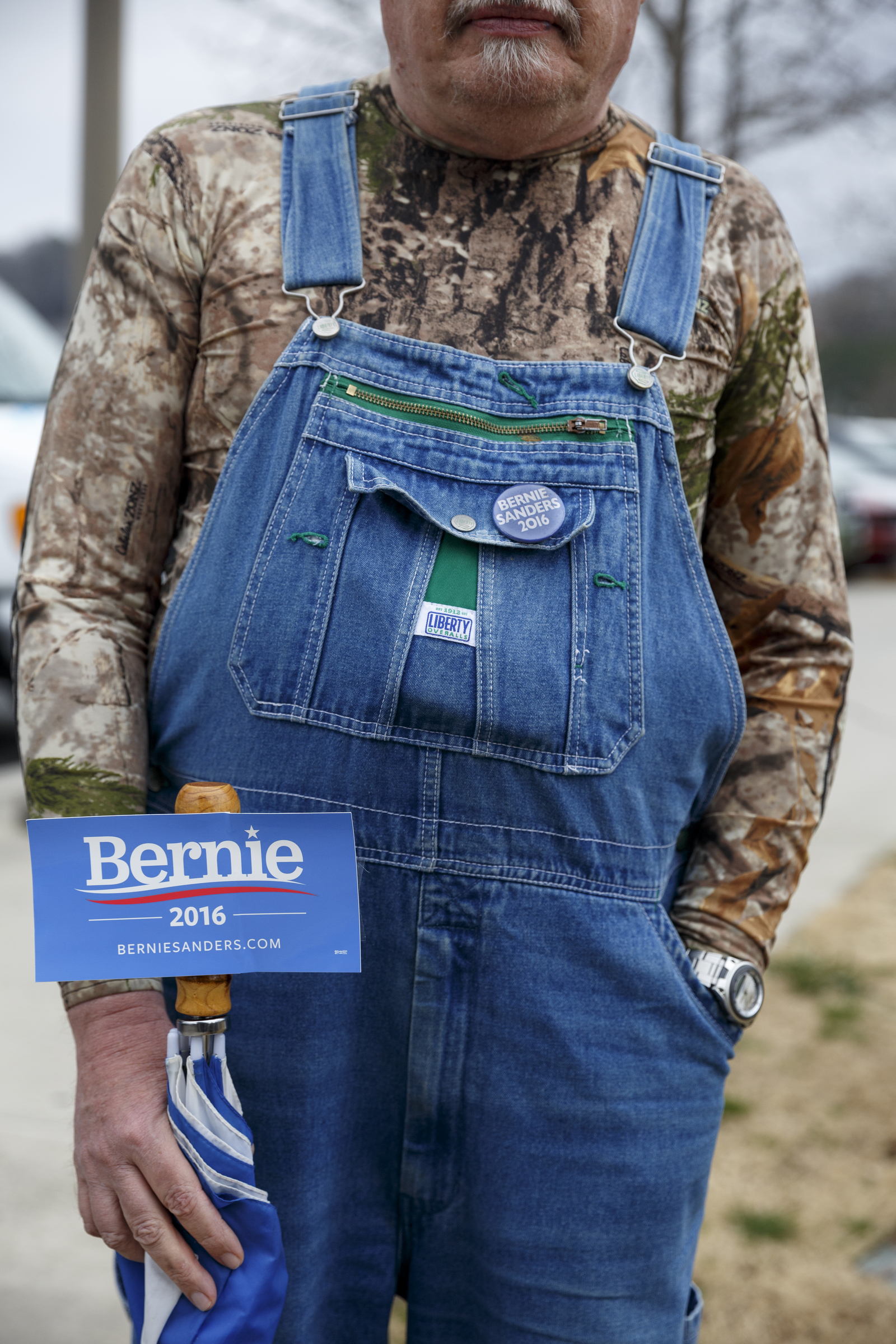 Tom Schultz wears a Sanders button and carries a sticker during a rally for Democratic presidential primary candidate Bernie Sanders held at Renaissance Park on Saturday, Feb. 20, 2016, in Chattanooga, Tenn. Supporters then marched across the Market Street Bridge to show their support.