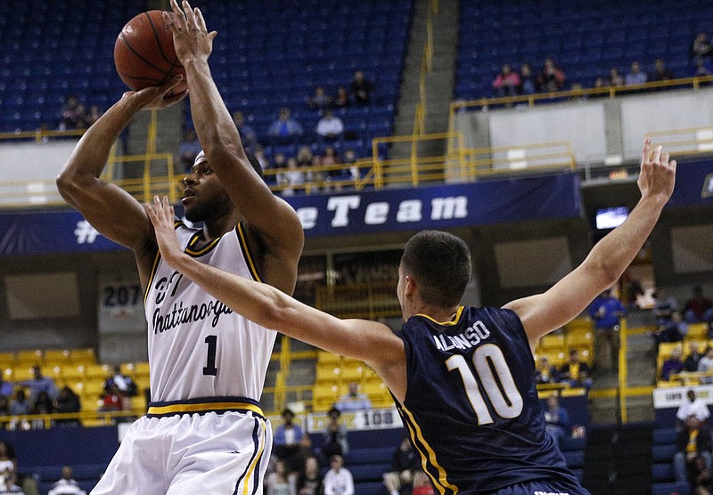 UTC guard Greg Pryor shoots around UNCG guard Francis Alonso during the Mocs' home basketball game against UNC Greensboro at McKenzie Arena on Saturday, Feb. 20, 2016, in Chattanooga, Tenn.