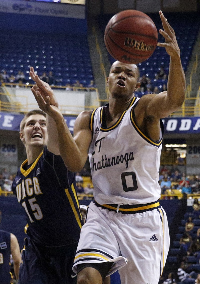 UTC forward Chuck Ester (0) rebounds the ball ahead of UNCG forward Garrett Collins during the Mocs' home basketball game against UNC Greensboro at McKenzie Arena on Saturday, Feb. 20, 2016, in Chattanooga, Tenn.