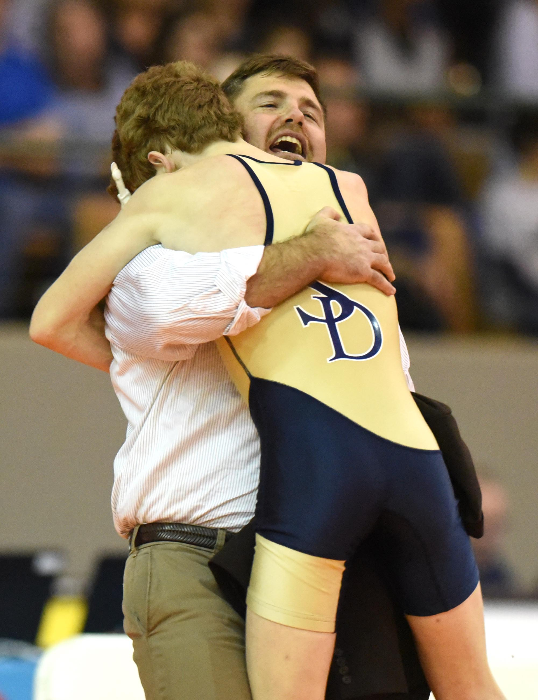 Soddy-Daisy head coach Jim Higgins hugs Charles Wheaton after Wheaton won the 106 pound class. The finals of the TSSAA State Wrestlings Championships were held at the Williamson Agricultural Center in Franklin, Tn. on February 20, 2016.