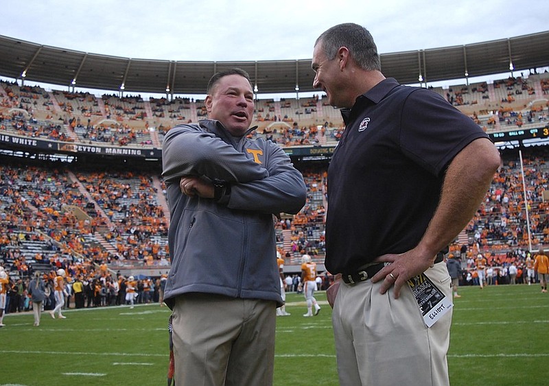 Tennessee head football coach Butch Jones (left) talks with South Carolina's interim head coach Shawn Elliott before the start of the game.  The South Carolina Gamecocks visited the Tennessee Volunteers in SEC football action November 7, 2015.