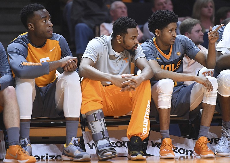 Tennessee guard Kevin Punter (0), center, sits on the bench with a leg brace with teammates Ray Kasongo (2) and Detrick Mostella (15), from left, during an NCAA college basketball game against LSU in Knoxville, Tenn., on Saturday, Feb. 20, 2016. Tennessee won 81-65. (Adam Lau/Knoxville News Sentinel via AP) MANDATORY CREDIT
