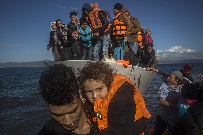 Migrants and refugees leave a vessel after their arrival from the Turkish coast to the northeastern Greek island of Lesbos. Tennessee senators insist the state sue to keep them out of the Volunteer State. (AP Photo/Santi Palacios)
