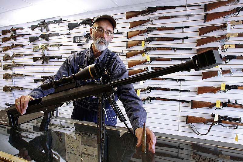 FILE - In this Dec. 4, 2008, file photo, Capitol City Arms Supply owner Steve Swartz shows off a Barrett .50-caliber rifle in Springfield, Ill. The Tennessee Senate on Wednesday, Feb. 24, 2016, gave final approval to a resolution designating the firearm as the states official state rifle. (AP Photo/Seth Perlman, File)