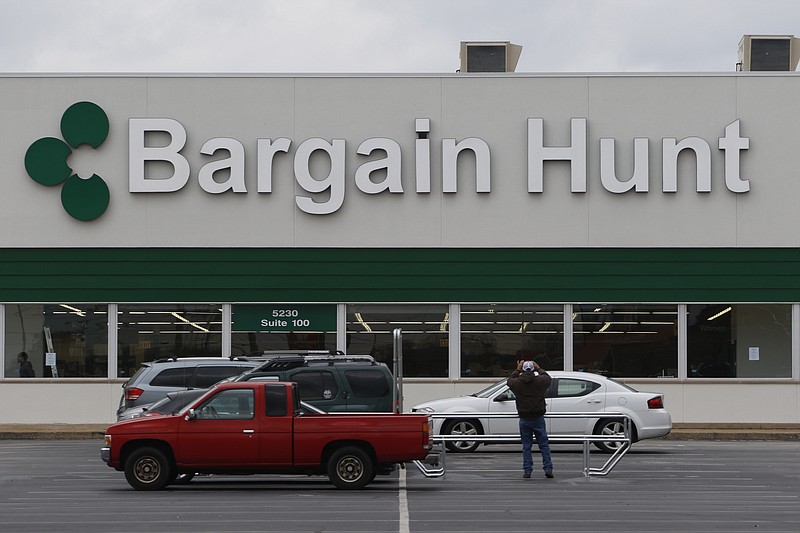 Staff Photo by Dan Henry / The Chattanooga Times Free Press- 2/25/16. A sign installer takes a photo of the new Hixson, Tenn., Bargain Hunt facade on Thursday, February 25, 2016. The retail store which occupies the old  Toys R Us location will open Friday, February 26, 2016. 