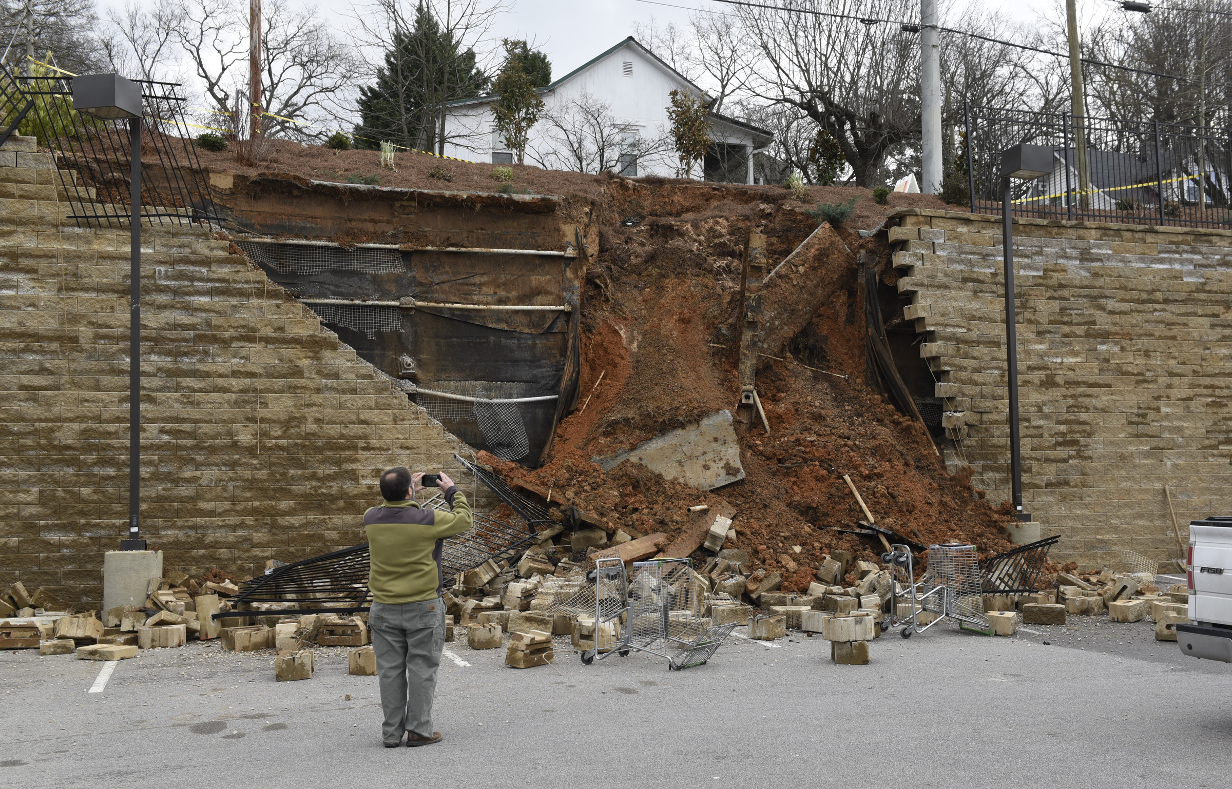 A man takes a photograph of a collapsed section of wall at a Publix grocery store parking lot in the North Chattanooga community on Thursday morning, Feb. 25, 2016, in Chattanooga, Tenn.