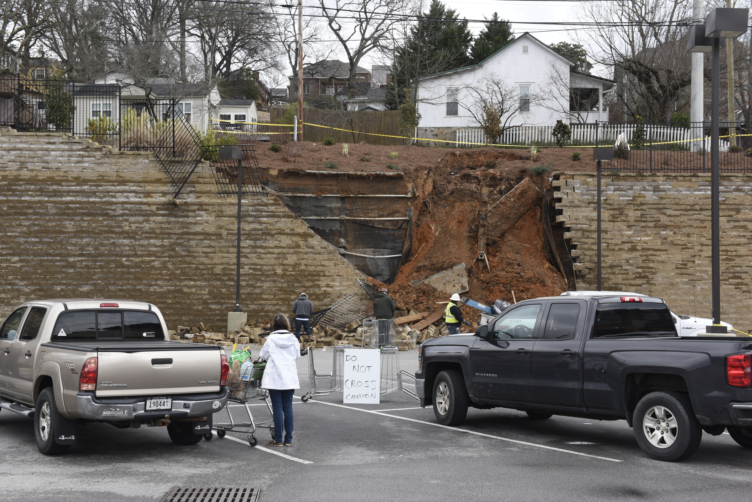 A customer brings her groceries to her car near a collapsed section of wall at a Publix grocery store parking lot in the North Chattanooga community on Thursday morning, Feb. 25, 2016, in Chattanooga, Tenn.