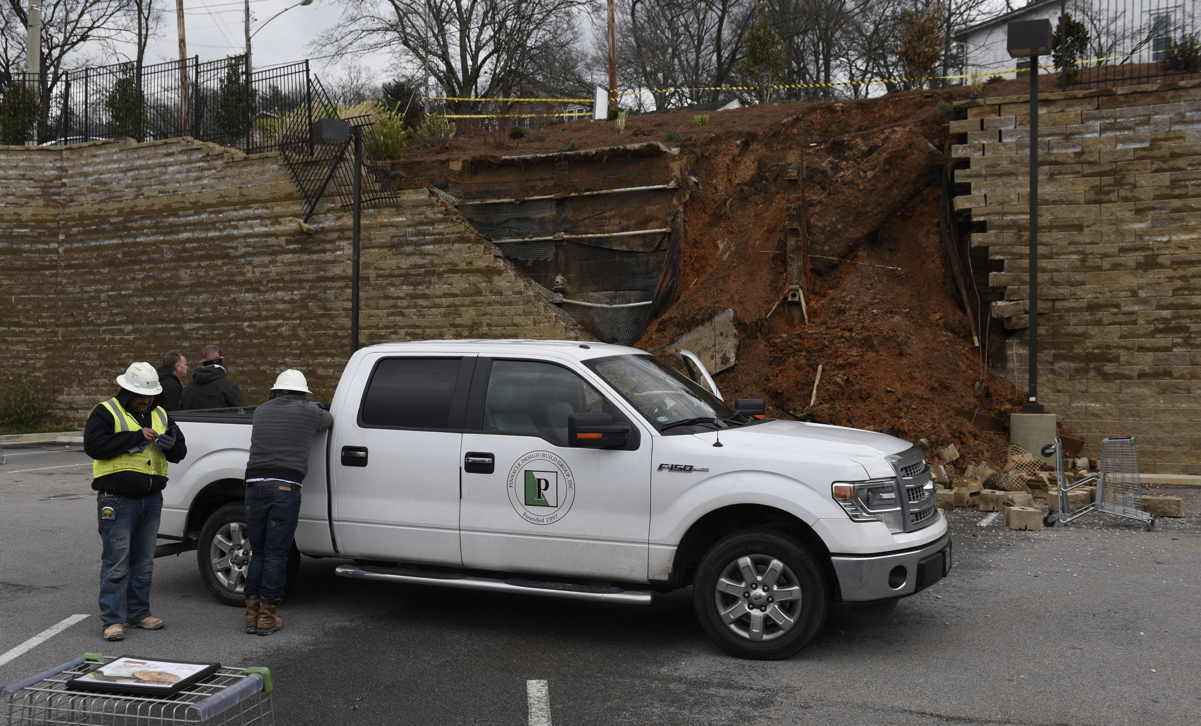Workers from Pinnacle Design/Build Group, Inc., park near a collapsed section of wall at a Publix grocery store parking lot in the North Chattanooga community on Thursday morning, Feb. 25, 2016, in Chattanooga, Tenn.