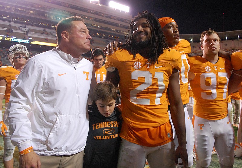 Tennessee coach Butch Jones, with his son Andrew at his side, smiles at linebacker Jalen Reeves-Maybin after the Volunteers' home win over Vanderbilt this past November.
