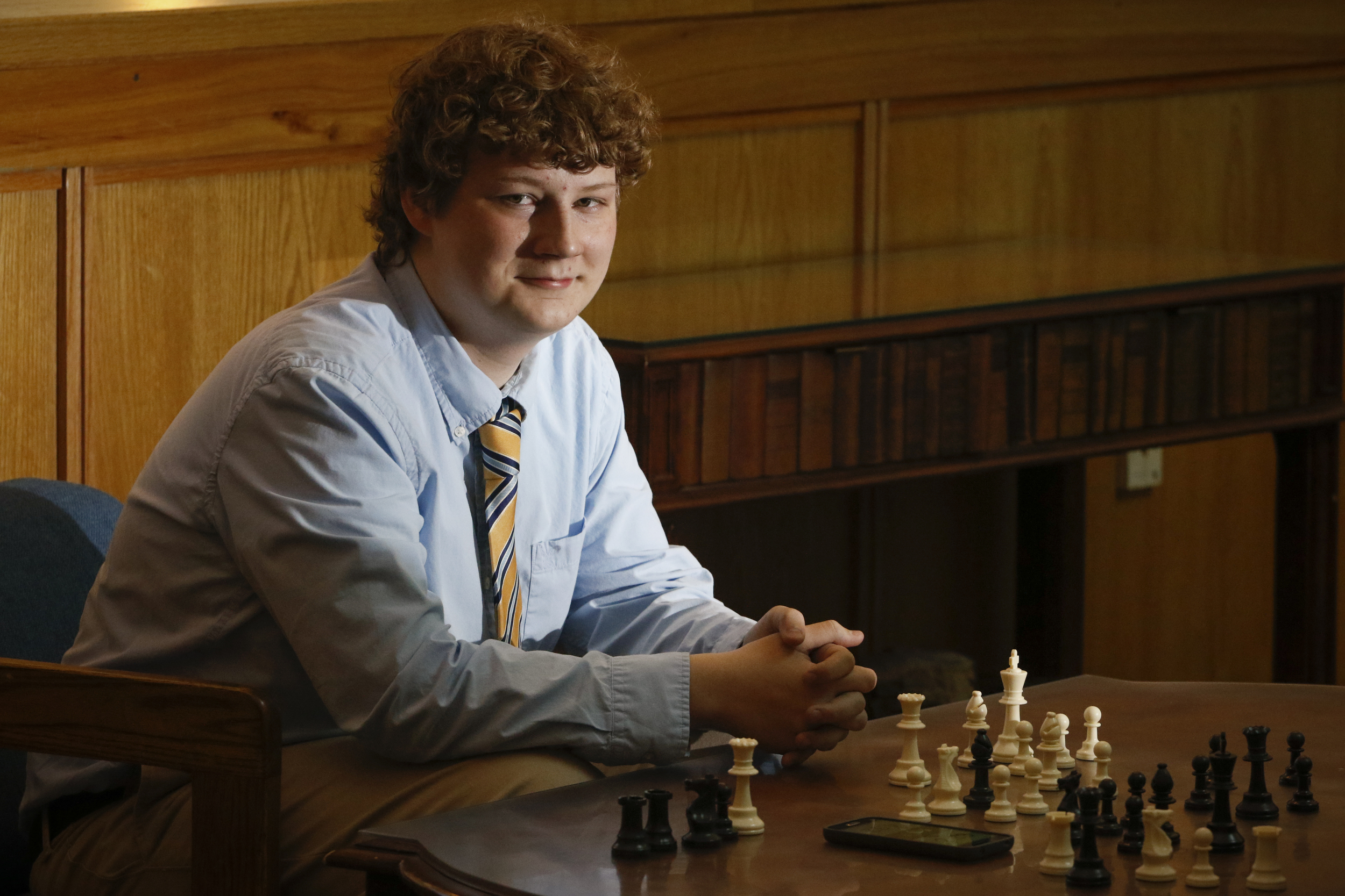 Staff Photo by Dan Henry / The Chattanooga Times Free Press- 2/19/16. McCallie School student Kaleb Gosdin, the Tennessee State Chess Champion, sits in front of the community chess table in the middle school building on Friday, February 19, 2016.