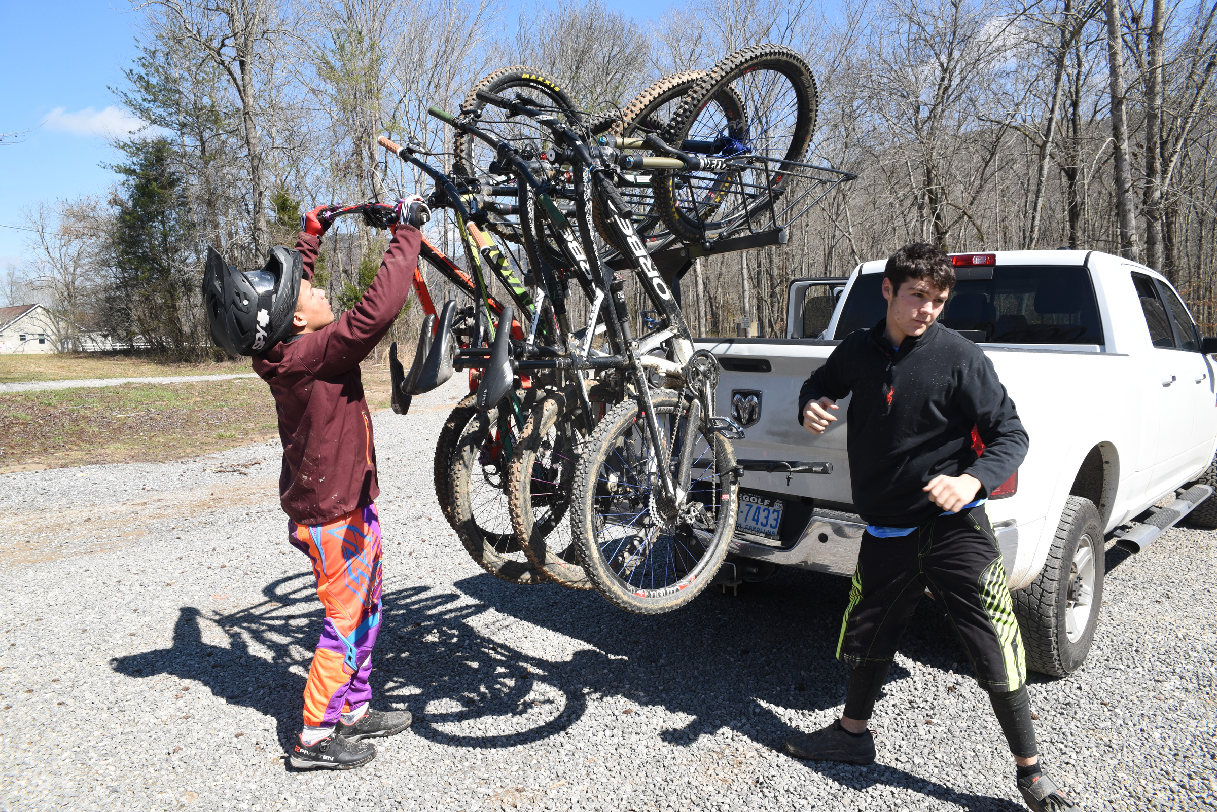 North Carolina rider Max Morgan, right, 17, makes a move to get another bicycle of the rack as Kai Nishinu, 18, hangs his before going to the top of Sequatchie Mountain in Marion County.