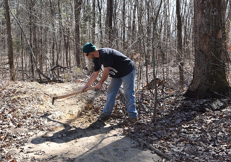 Troy Roberts prepares a place on the trail Friday atop Sequatchie Mountain. The trail drops 1,050-feet in 1.1-miles into Coppinger Cove in Marion County.