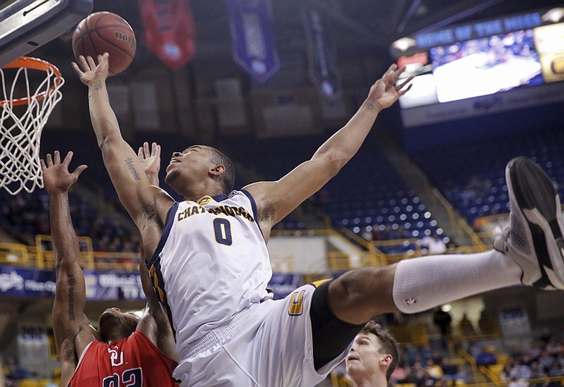 UTC forward Chuck Ester shoots over Samford forward Iman Johnson during Saturday's game at McKenzie Arena. The Mocs won 77-66 to claim at least a share of the SoCon regular-season championship, but they can claim that title outright with a win tonight at VMI.