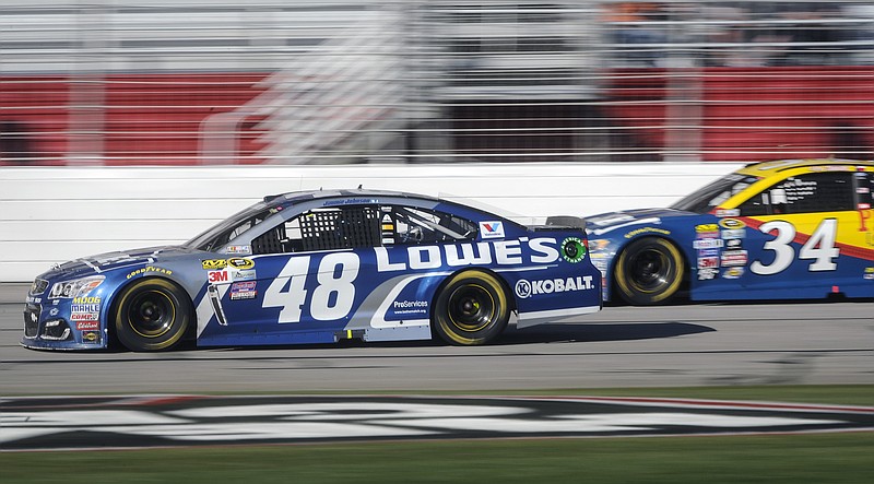 Jimmie Johnson (48) passes Chris Buescher (34) during a NASCAR Sprint Cup Series auto race at Atlanta Motor Speedway, Sunday, Feb. 28, 2016, in Hampton, Ga. (AP Photo/John Amis)