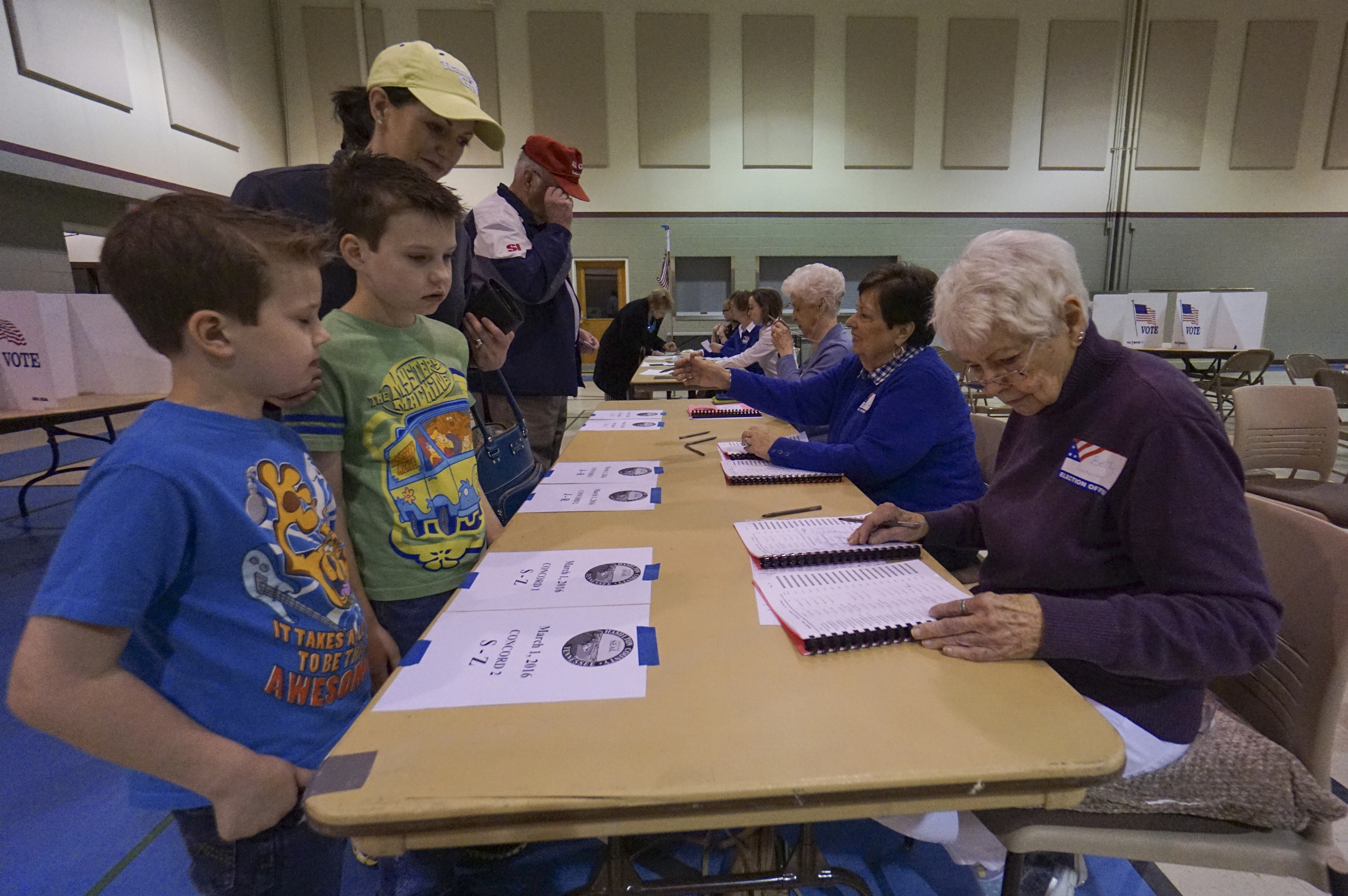 Micah, 7, and Jonah, 9, stand with their mother Tisha Walker as she receives her ballot from Betty Lombardo while at Concord Baptist Church in East Brainerd on Super Tuesday, March 1, 2016.