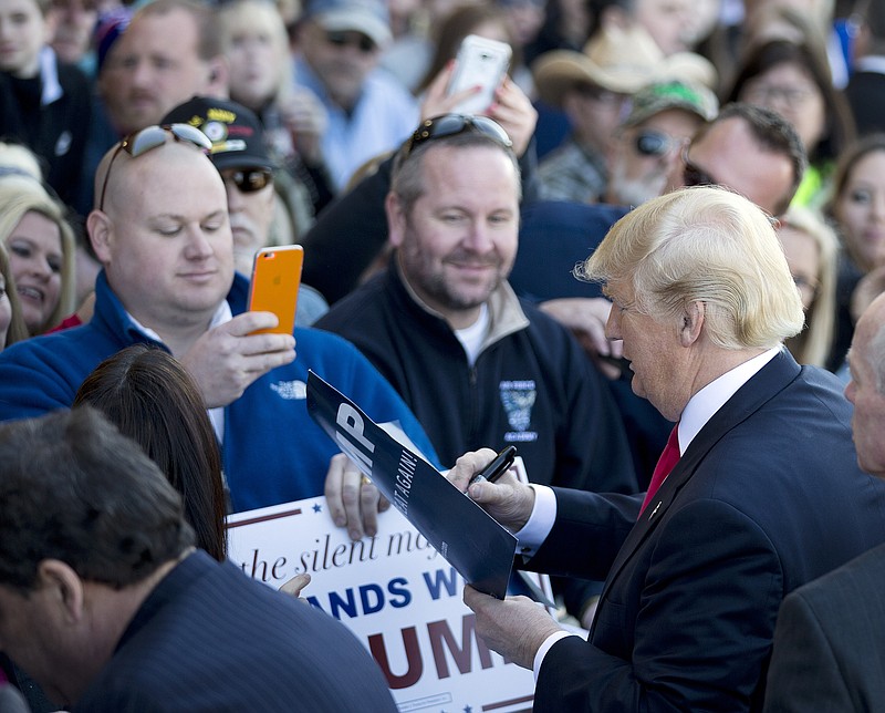 Republican presidential candidate Donald Trump signs autographs during a recent rally in Arkansas.