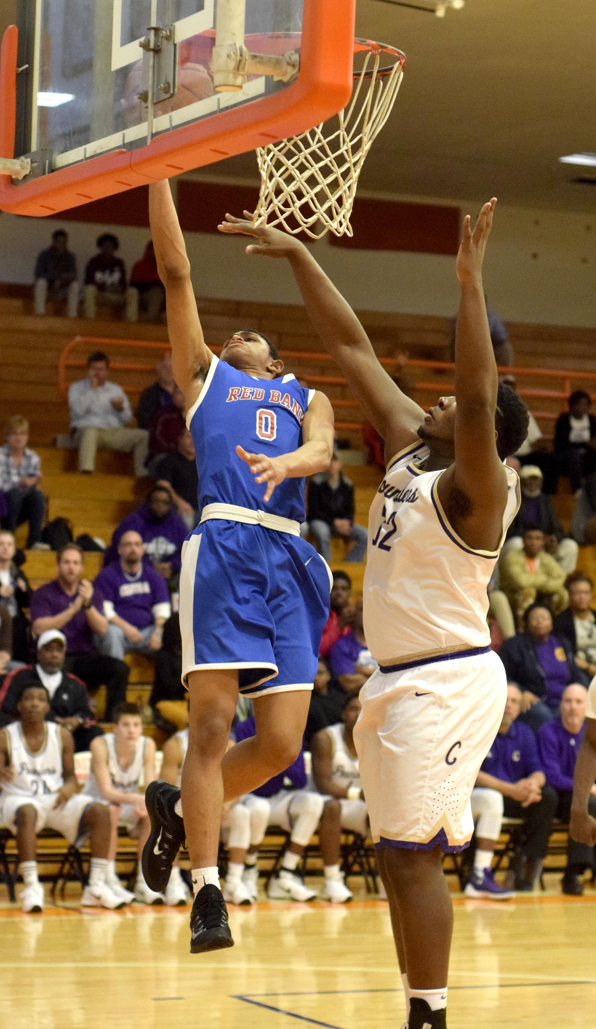 Red Bank's Kolbi Suttles (0) lays the ball in while Central's McClendon Curtis (32) defends. The Central Purple Pounders faced the Red Bank Lions in the semi-finals of the Region 3-AA basketball tournament at East Ridge High School Tuesday March 1, 2016.