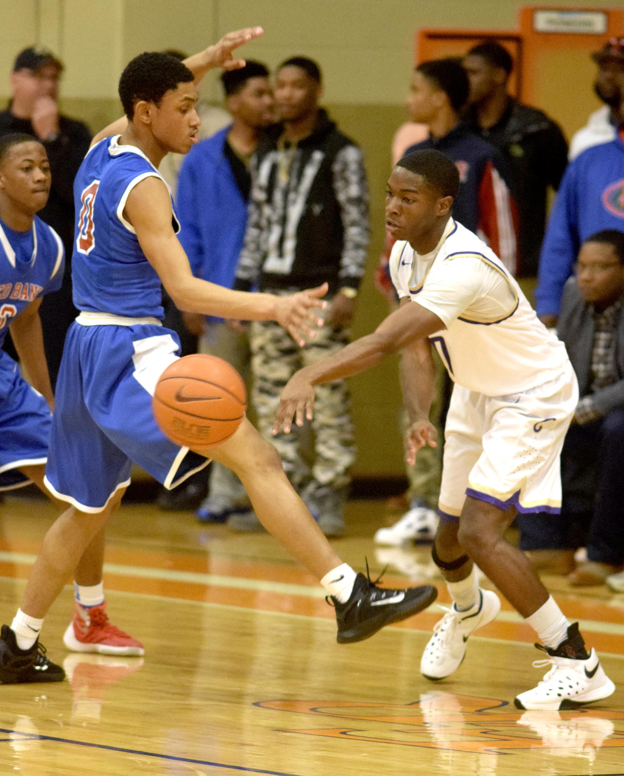 Central's Dahon Baxter (10) passes the ball past Red Bank's Kolbi Suttles (0). The Central Purple Pounders faced the Red Bank Lions in the semi-finals of the Region 3-AA basketball tournament at East Ridge High School Tuesday March 1, 2016.